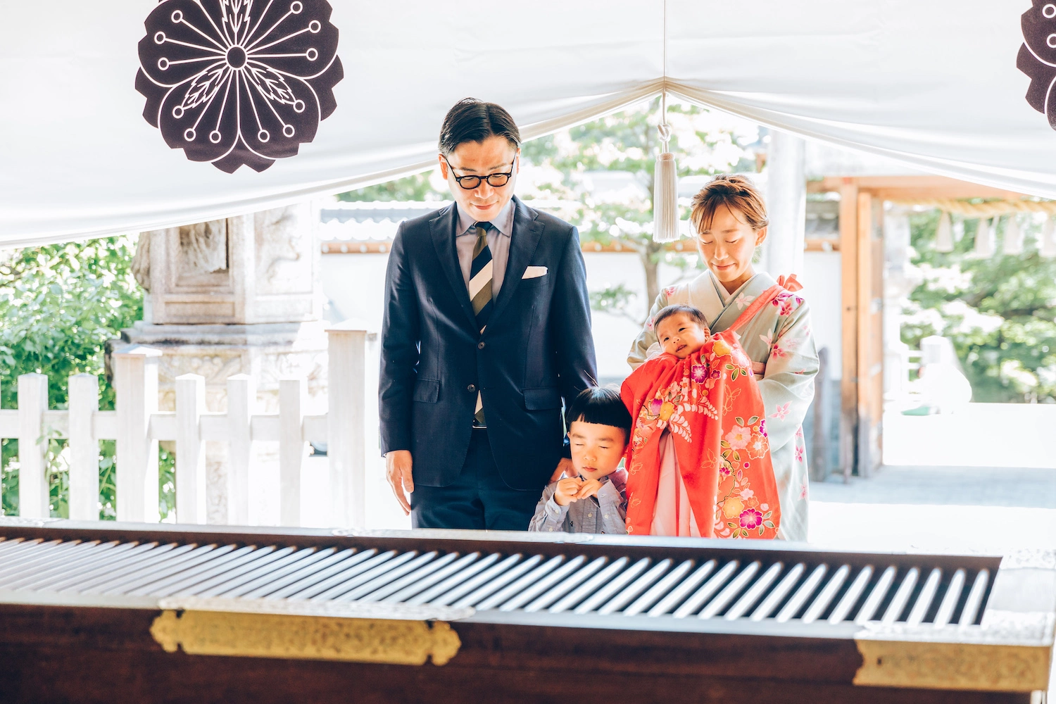 神社でお宮参りをする家族